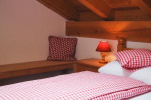 a bedroom with two beds and a lamp on a bench at Ferienwohnung Alpenwelt in Mittenwald