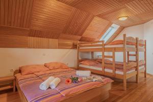 two bunk beds in a room with wooden ceilings at Oblak Estate Apartments in Ortnek