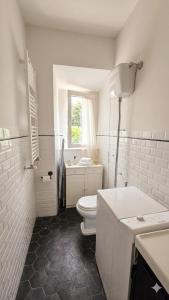 a white bathroom with a toilet and a sink at Da nonno Carlo Lakeview - By BorgoLago in Capodimonte