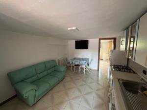 a living room with a green couch and a table at LB Guest House in Tagliacozzo