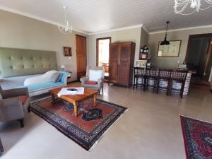 a living room with a couch and a table at Somerset Grace Cottage in Somerset West