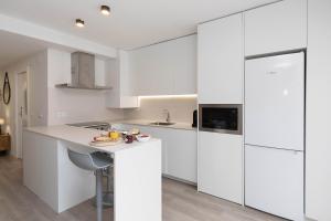 a white kitchen with white cabinets and a sink at Sky Biescas II by BeValle in Biescas