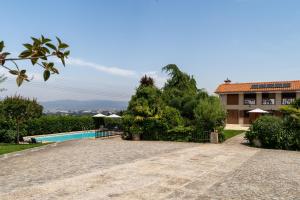 a resort with a swimming pool and a building at Casas da Aldeia da Graça in Guimarães