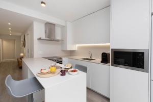 a white kitchen with a plate of food on a counter at Sky Biescas II by BeValle in Biescas