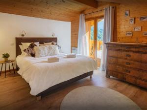 a bedroom with a large bed and a wooden wall at Chalet Aravista - OVO Network in Le Grand-Bornand
