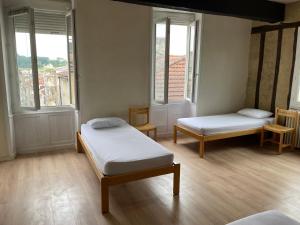 a room with two beds and two windows at Gîte de la cathédrale 2 in Condom