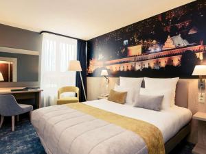 a hotel room with a large bed and a desk at Mercure Lublin Centrum in Lublin +93 photos