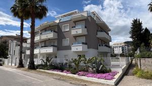 a large apartment building with palm trees in front of it at Palladio13 in San Benedetto del Tronto
