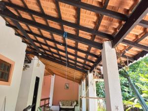 a wooden pergola on a house at Chalé casa na mata Jasmim in Guararema