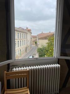 a window with a radiator and a view of a street at Gîte de la cathédrale 2 in Condom +3 photos
