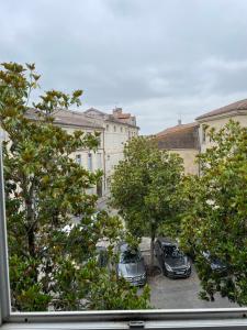 a view of cars parked in a parking lot with trees at Gîte de la cathédrale 2 in Condom