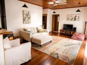 a living room with a couch and a tv at Thrums Bush Retreat in Upper Orara
