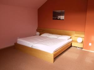 a bedroom with a large bed with white sheets at Obecní dům Mokré Lazce in Opava
