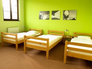 three beds in a room with green walls at Obecní dům Mokré Lazce in Opava
