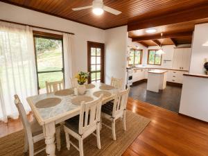 a kitchen and dining room with a table and chairs at Thrums Bush Retreat in Upper Orara