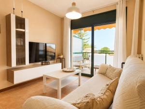 a living room with a couch and a tv at Apartamento L'Eucaliptus, Delta del Ebro in Amposta