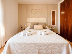 a bedroom with a large bed with towels on it at Apartamento L'Eucaliptus, Delta del Ebro in Amposta