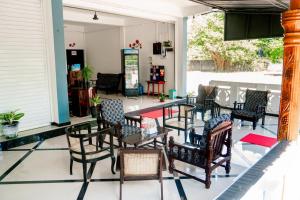 a group of chairs and tables on a patio at Alles garden New Seaside in Trincomalee