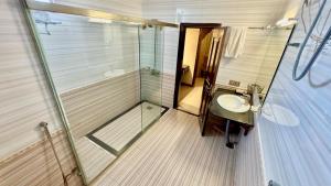 a bathroom with a glass shower and a sink at Shelton's Rezidor Peshawar in Peshawar +36 photos