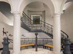 a staircase with columns and benches in a building at Century Old Town Prague - MGallery Collection in Prague