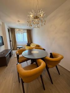 a dining room with a table and yellow chairs at Kokolino in Irig