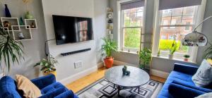 a living room with a blue couch and a table at Double Bed at Cozy Hailsham in London