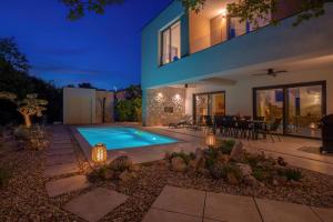 a house with a swimming pool in a yard at Villa Elementa Krk - Luxury Four Elements Experience in Krk