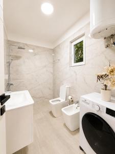 a white bathroom with a toilet and a sink at Deon in Vlorë +13 photos