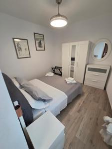 a bedroom with two beds and a table and a mirror at Casa del nonno Gino in Pietrasanta