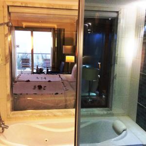 uma casa de banho com banheira e um quarto com cama em Xperience Sea Breeze Resort em Sharm El Sheikk