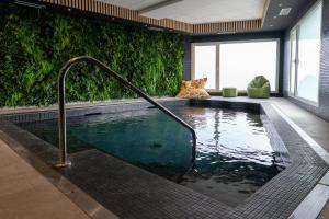 a swimming pool with a faucet in a building at Hotel Libera Spa et Restaurant Caen Colombelles in Caen
