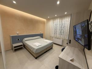 a bedroom with a bed and a flat screen tv at B&B Capo Vaticano Stay in Capo Vaticano