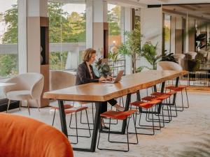 a woman sitting at a table with a laptop at Novotel Paris Centre Tour Eiffel in Paris +203 photos
