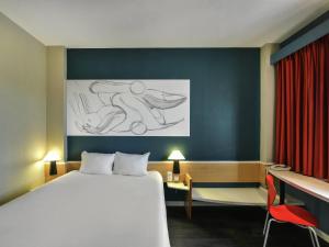 a hotel room with a bed and a desk and a drawing at Ibis Madrid Getafe in Getafe +121 photos