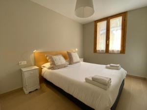 a bedroom with a bed with white sheets and a window at Apartamento Casa Francho in Panticosa