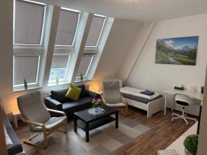 a living room with a couch and chairs and windows at CityApartment Platinum-Zentrum mit Parkplatz in Bielefeld