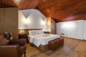 a bedroom with a large bed and a couch at Casas da Aldeia da Graça in Guimarães +59 photos