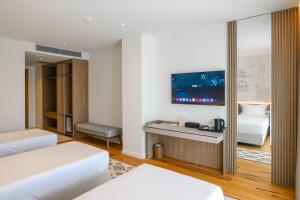 a hotel room with two beds and a flat screen tv at CITADEL Heritage Hotel Berat in Berat +258 photos