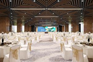 a large banquet hall with white tables and chairs at Flamingo Cat Ba Beach Resort in Cat Ba +93 photos
