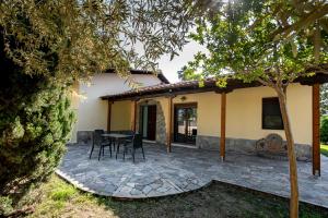 a patio with a table and chairs in front of a house at Fourka Garden Villas in Fourka