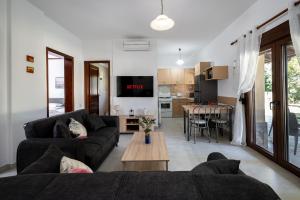 a living room with a couch and a table at Fourka Garden Villas in Fourka