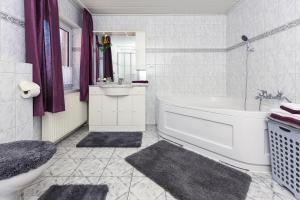 a white bathroom with a tub and a sink at Ferienwohnung im Haus Katja in Dunum +13 photos