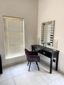 a black desk with a chair and a mirror at Ridgeworth Royale in Tyger Valley