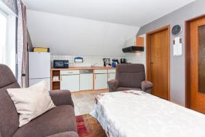 a room with a bed and two chairs and a kitchen at Ferienwohnung im Haus Katja in Dunum
