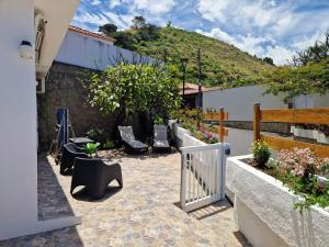 a patio with chairs and plants and a fence at Chalet JULI Mirador in Puerto de la Cruz