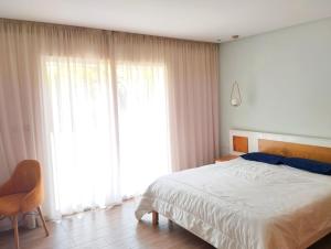 a bedroom with a bed and a large window at Luxury big House in hearth of Hay Riad with big garden in Rabat