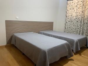 two beds sitting next to each other in a room at Bento Lodge by Madeira Holiday Rentals in Ribeira Brava