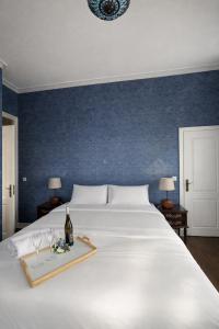 a white bed with a bottle of wine and two glasses at Palacete da Vermelha in Vermelho