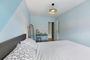 a bedroom with a white bed and a desk at Gite Logeraie in Le Boupère