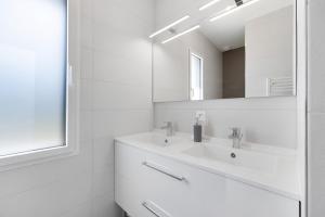 a white bathroom with a sink and a mirror at Gite Logeraie in Le Boupère +14 photos